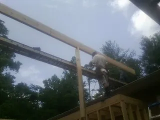 Carpenter setting a ridge beam over a new addition frame — Ice Dam Removal by Roofing Brothers in Gayville