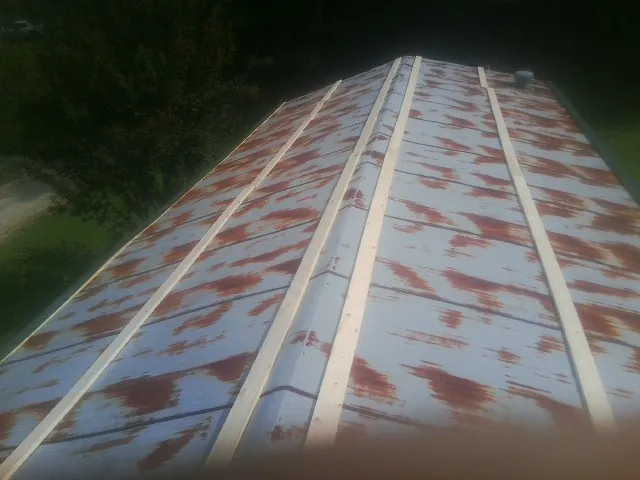 Rusted metal roof panels with new wood purlins before replacement — Storm Damage Roof Repair in Gayville by Roofing Brothers