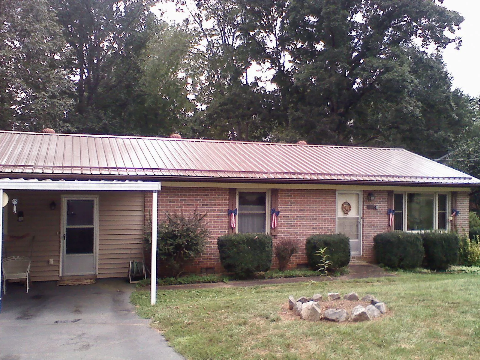 Bronze metal roof and carport on a brick ranch home — Roof Repair work by our crew in Gayville
